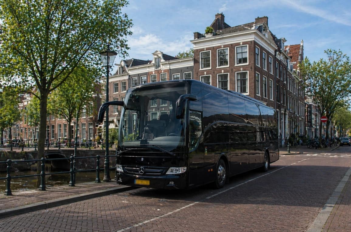 Interior of a luxury coach with reclining seats and entertainment screen